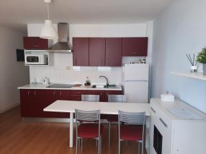 a kitchen with a table and chairs and a refrigerator at Seaside Apartment Gran Canaria in La Garita