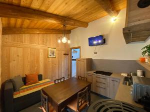 eine Küche mit Holzwänden, einem Tisch und einem Sofa in der Unterkunft L'Oasi di Sodani 2 in Sampeire