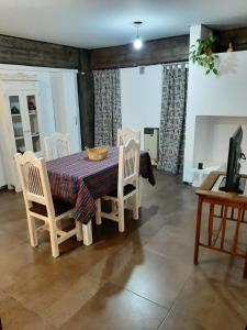 ein Esszimmer mit Tisch und Stühlen und einem Fernseher in der Unterkunft Sarmiento 430 in San Salvador de Jujuy