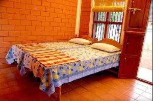 a small bed in a room with a table at Dazzle Dew in Alleppey