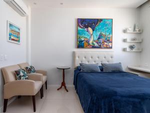 1 dormitorio con 1 cama y una pintura en la pared en Studio Catete, en Río de Janeiro