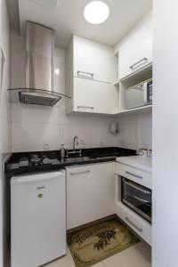 una cocina con armarios blancos y fregadero en Studio Catete, en Río de Janeiro