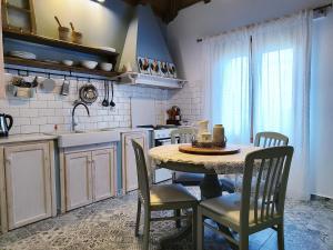 a kitchen with a table and chairs in a kitchen at Habezeiko - The Vintage House in Afitos