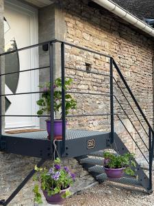 a porch with two potted plants on the stairs at nuitzen in Boyer