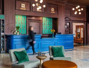a woman walks past a blue bar in a lobby at Landmark Inn in Marquette