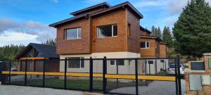 a house with a fence in front of it at PH Design Entre Pinos in San Carlos de Bariloche