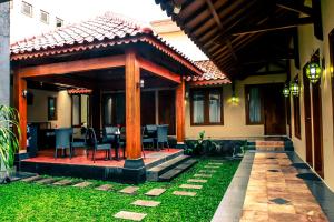 Casa con patio cubierto con mesa y sillas en Griya Wijilan Syariah en Yogyakarta