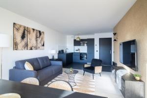 sala de estar con sofá azul y cocina en Appartement idéal pour 8 personnes près de Disneyland Paris #18, en Chessy