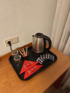 a tray with a tea kettle on a table at City Pension in Rastatt