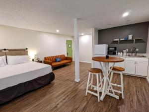a bedroom with a bed and a table and a kitchen at The Honey Bee Motel in Dunlap