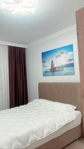 een slaapkamer met een bed met een foto aan de muur bij TURGUT REZİDANS in Bostancı
