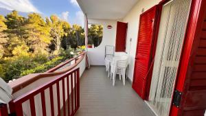 a balcony with a red door and chairs on it at Residence Jolly in Peschici