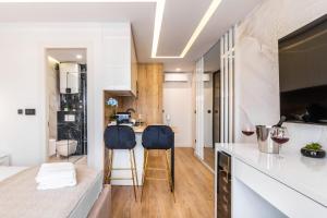 a kitchen with white counters and two blue stools at Sky Residence Split in Split