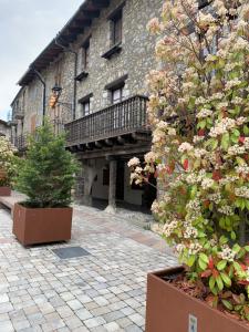 a brick building with a balcony and some plants at CAL JAN - La Muralla in Bellver de Cerdanya 