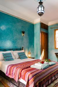 - une chambre avec un grand lit aux murs bleus dans l'établissement Riad Bianca Marrakech, à Marrakech