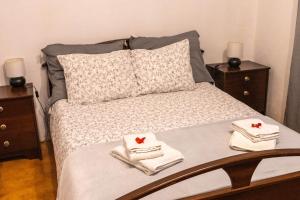 a bedroom with a bed with towels and two night stands at Quinta dos Pinheiros in Estanqueiro