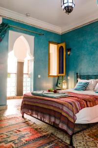 sypialnia z dużym łóżkiem z niebieskimi ścianami w obiekcie Riad Bianca Marrakech w Marakeszu