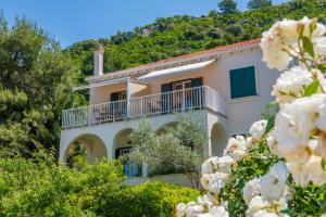 a house with a balcony and white flowers at Apartments Mirjana Mljet in Prožura