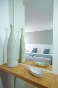 two vases sitting on a wooden table with a bed at LAR DA REVOLTA in Cedeira