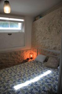 a bedroom with a bed with a window and a lamp at Gite charme et campagne in Montazeau