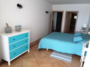 1 dormitorio con 1 cama azul y vestidor en CASA DA CALIFORNIA SESIMBRA, en Sesimbra