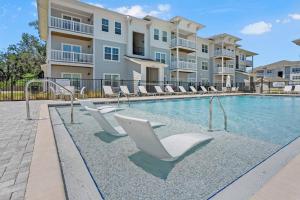 a swimming pool with lounge chairs in front of a building at Tranquil Serenity - Exchange at Orange Park in Jacksonville