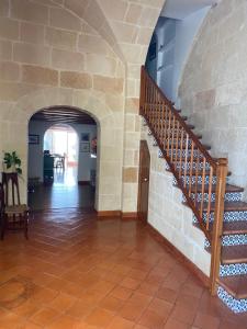a hallway with a staircase and a stone wall at Santa Rosalia in Ciutadella