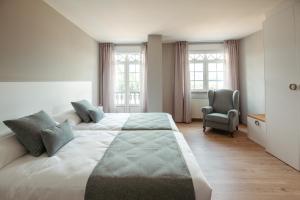 a bedroom with a large bed and a chair at LAR DA REVOLTA in Cedeira