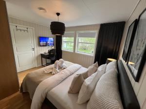 um quarto com uma cama grande e lençóis brancos em Bratsberg Apartment - with Kitchenette and Free Parking em Trondheim