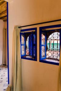 two windows with blue trim on a wall at Riad Bianca Marrakech in Marrakesh