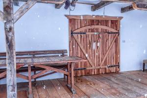 a room with a wooden door and a wooden bench at Casa dintre dealuri in Rozavlea