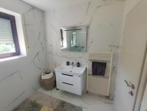a white bathroom with a sink and a mirror at Ferienwohnung Marin - neu in Kastav +7 photos