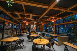 ein Restaurant mit Holztischen, Stühlen und Fenstern in der Unterkunft Riad Bella Montana in Fès