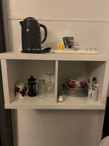 uma prateleira com um bule de chá e pratos sobre ele em McCoinnich Rooms em Dundee