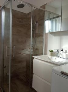uma casa de banho com um chuveiro e um lavatório. em Apartman Punta Radman em Petrcane