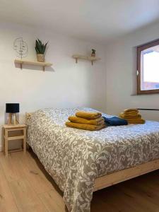 1 dormitorio con 1 cama con mantas y ventana en Les Lavandières Scherwiller en Scherwiller