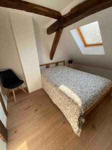 1 dormitorio con 1 cama y 1 silla en Les Lavandières Scherwiller, en Scherwiller