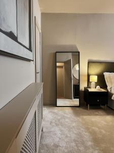 a bedroom with a mirror and a bed and a table at Todmorden Town Centre Apartment in Todmorden