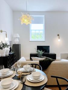 a dining room with a table with plates and wine glasses at Todmorden Town Centre Apartment in Todmorden