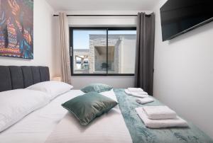 ein Bett mit zwei Kissen und ein Fenster in einem Zimmer in der Unterkunft Villa LaRimar **** in Sukošan