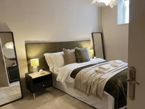 a bedroom with a large bed and a mirror at Todmorden Town Centre Apartment in Todmorden +29 photos