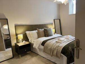 a bedroom with a large bed and a mirror at Todmorden Town Centre Apartment in Todmorden