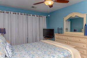 1 dormitorio con 1 cama y TV de pantalla plana en 703 Spinnaker Beach House, en Seabrook Island