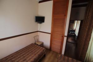 a small room with a bed and a television at Uyutniy in Odesa