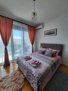 a bedroom with a large bed with pink towels on it at Kalina Trebinje in Trebinje