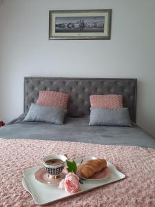 a tray with a cup of coffee and a pastry on a bed at Kalina Trebinje in Trebinje