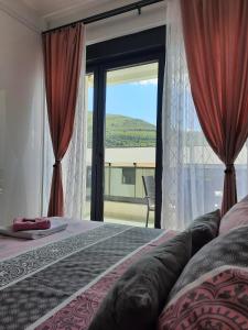 a bedroom with a bed and a large window at Kalina Trebinje in Trebinje