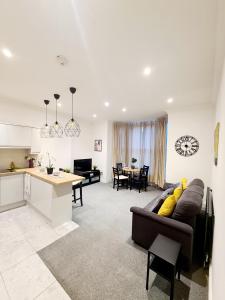 ein Wohnzimmer und eine Küche mit einem Sofa und einem Tisch in der Unterkunft Stunning 2 Bed 2 Bath Luxury London Apartment! in Forest Hill