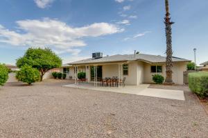 a house with a patio and a palm tree at Sun City Retreat with Patio Near Golfing and Hiking! in Sun City