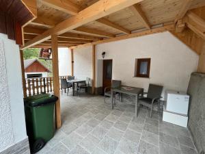 a patio with a table and chairs and a wooden ceiling at Apartmaji in Sobe Cuder in Soča